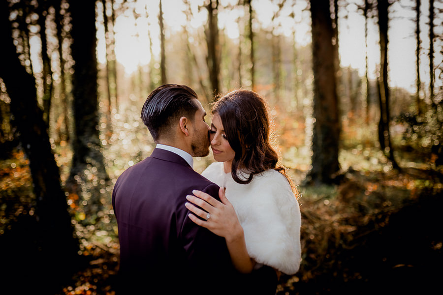 Bride and groom kissing in a forest