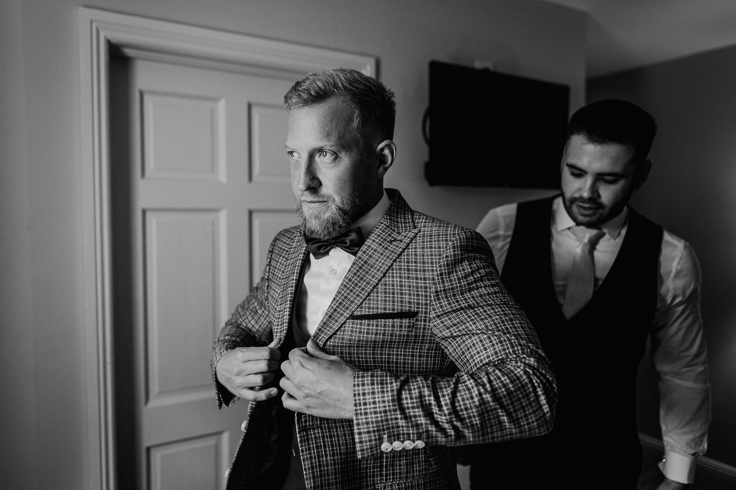 groom closing a button on his coat