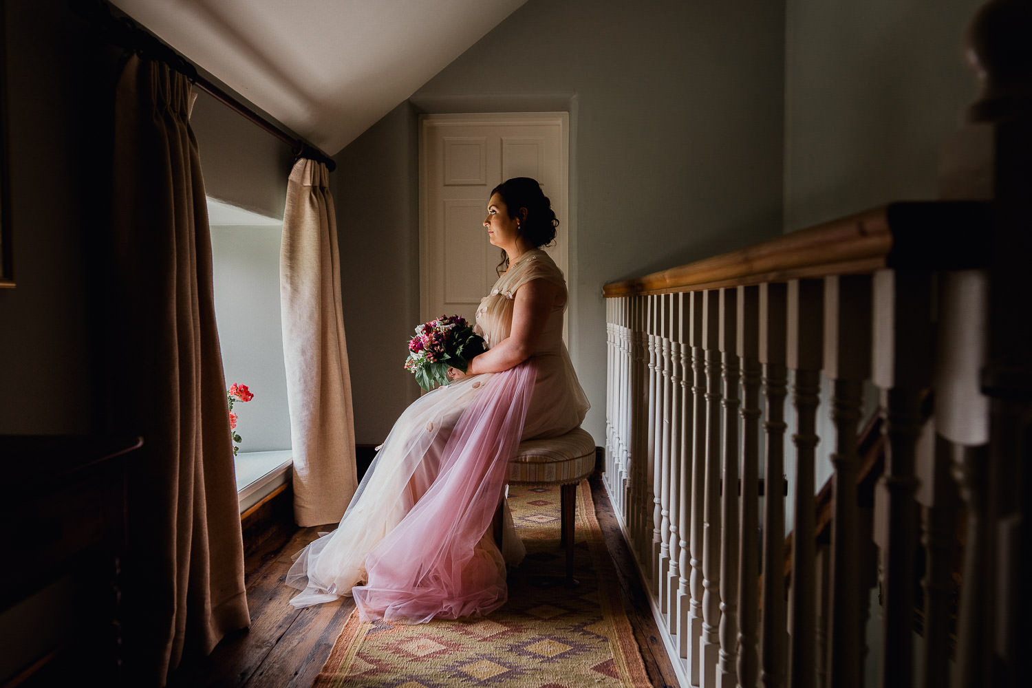 bride sitting on a chair in window light