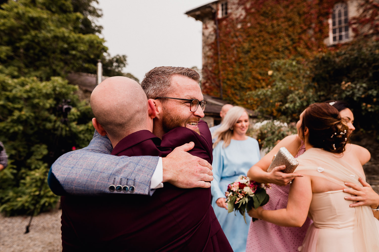 groom hugging wedding guests