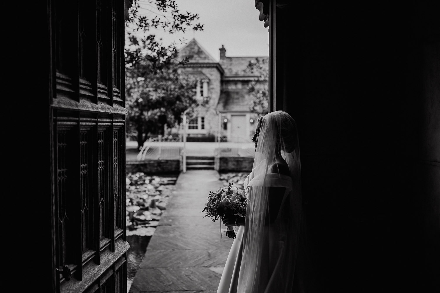 bride standing in doorway holding flowers
