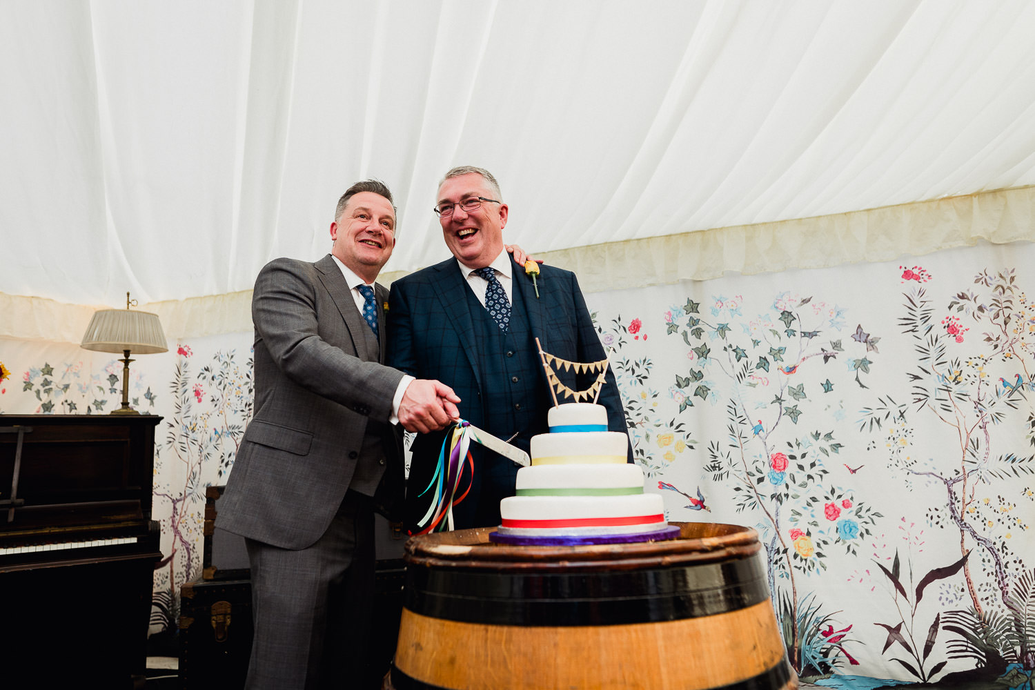 groom and groom cutting wedding cake