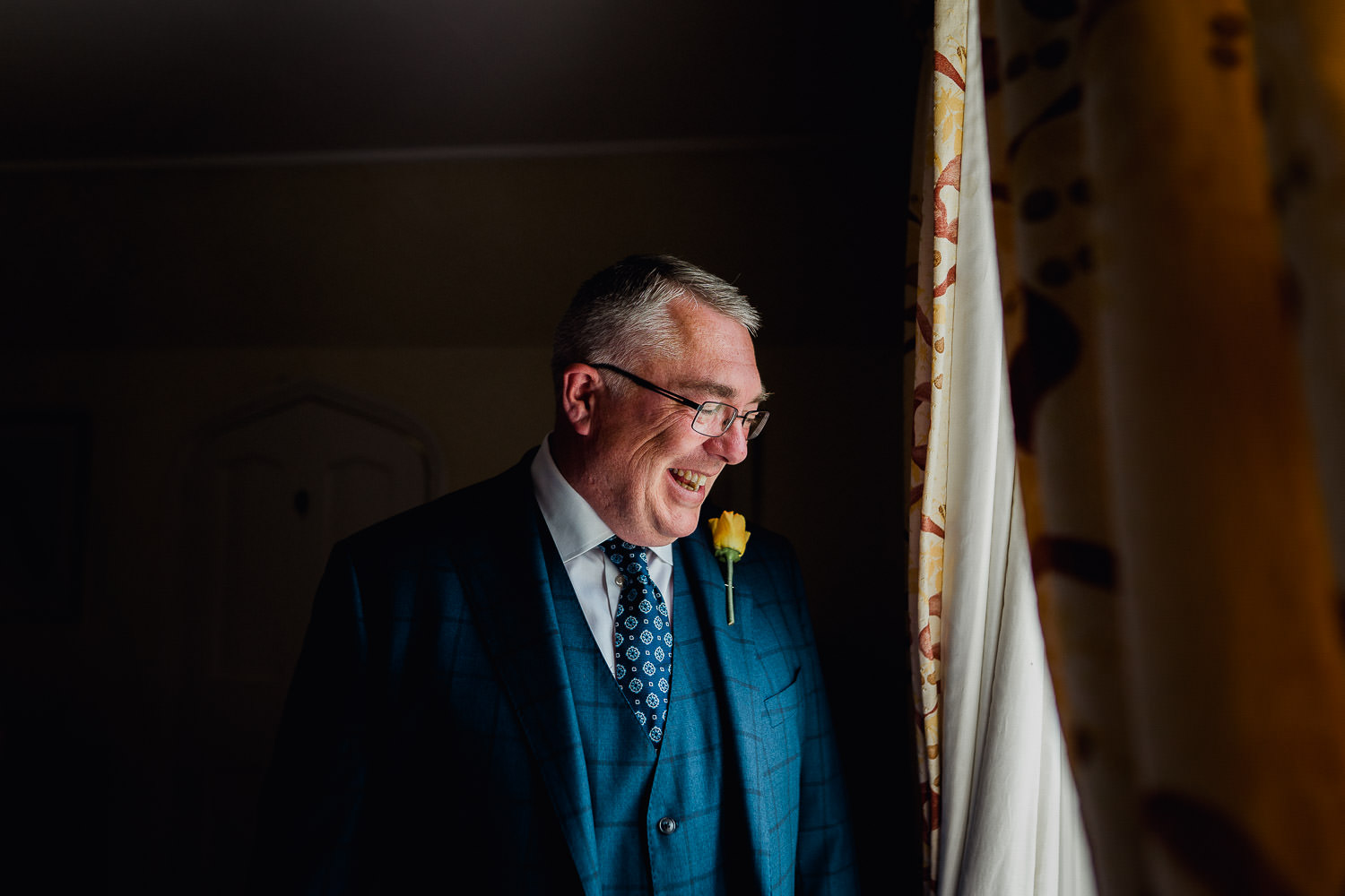 groom standing in window light at Martinstown House