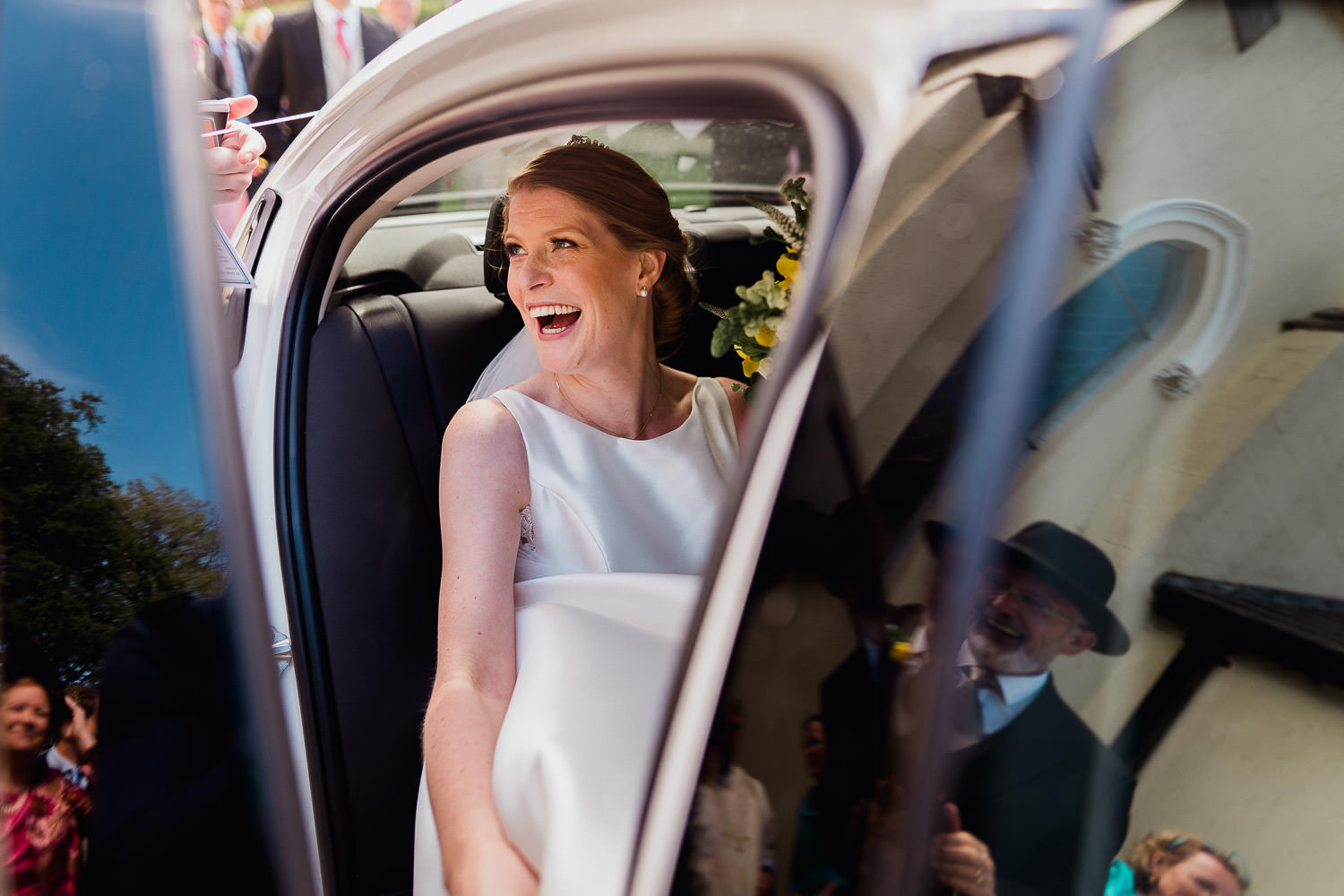 bride sitting in a car smiling
