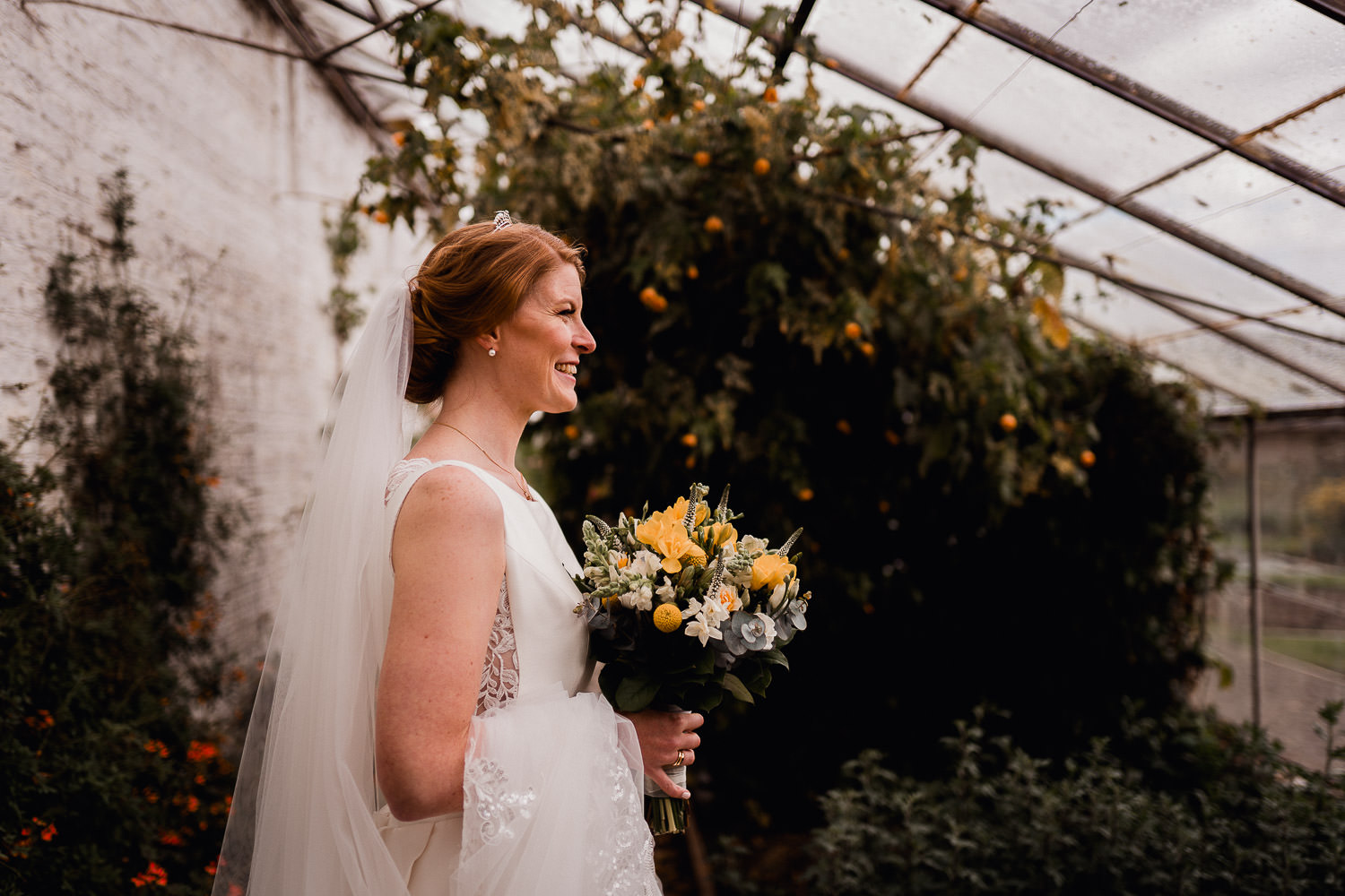 brideholding a bunch of yellow and white flowers