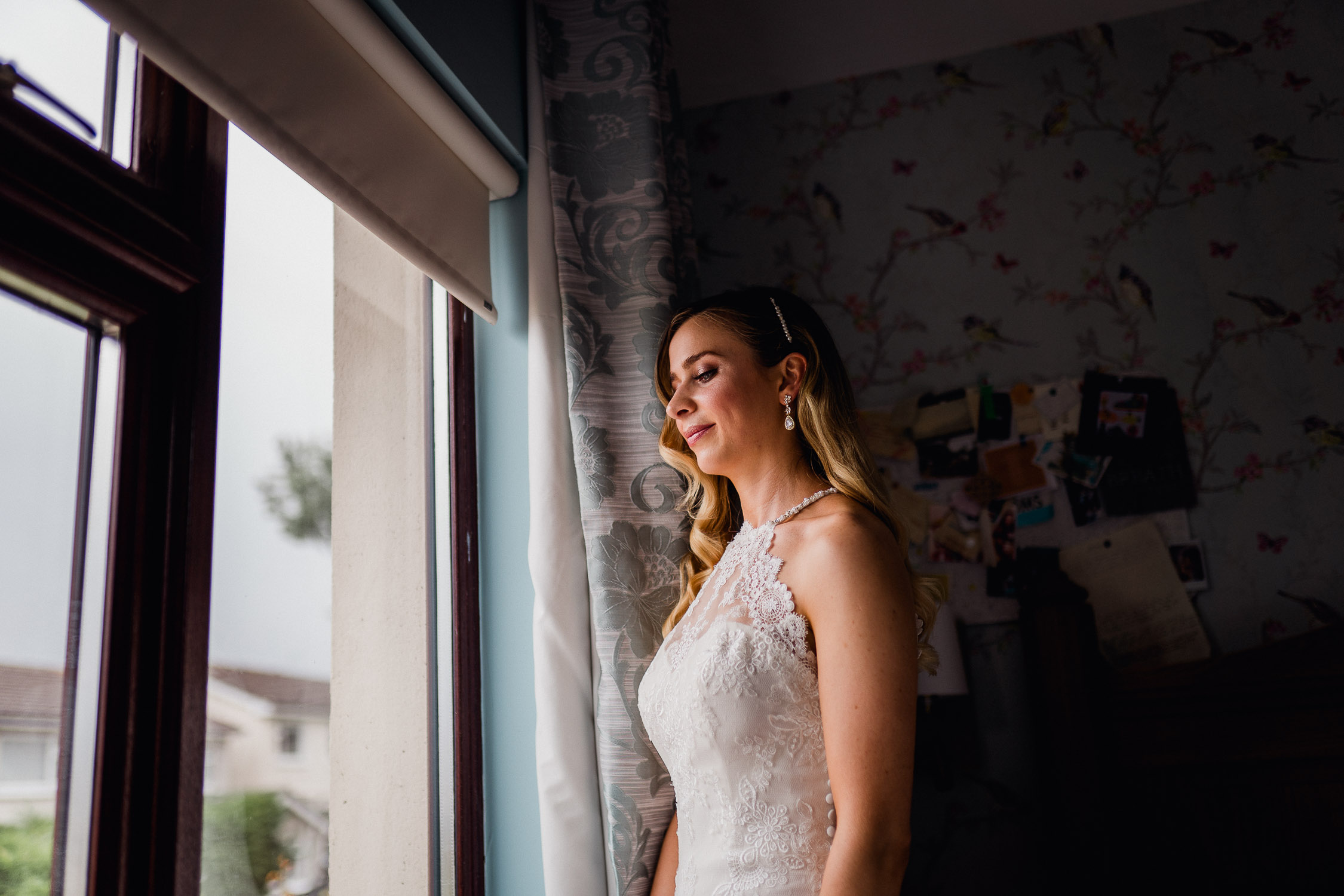bride standing in window light
