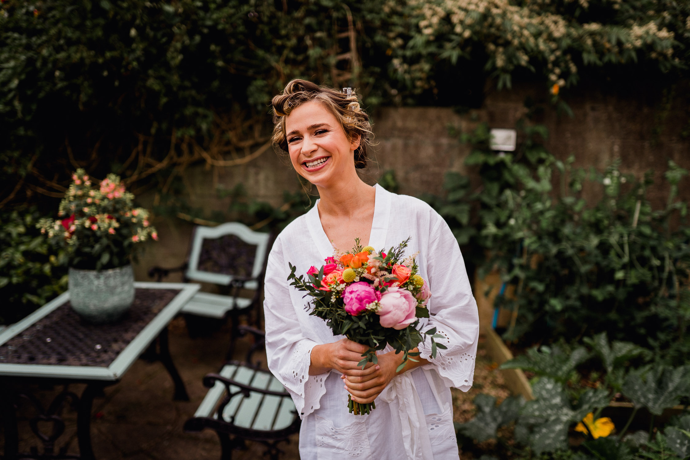 Bride standing in a garden holding flowers
