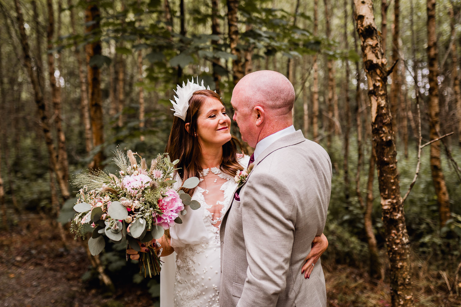 bride hugging groom in a forest