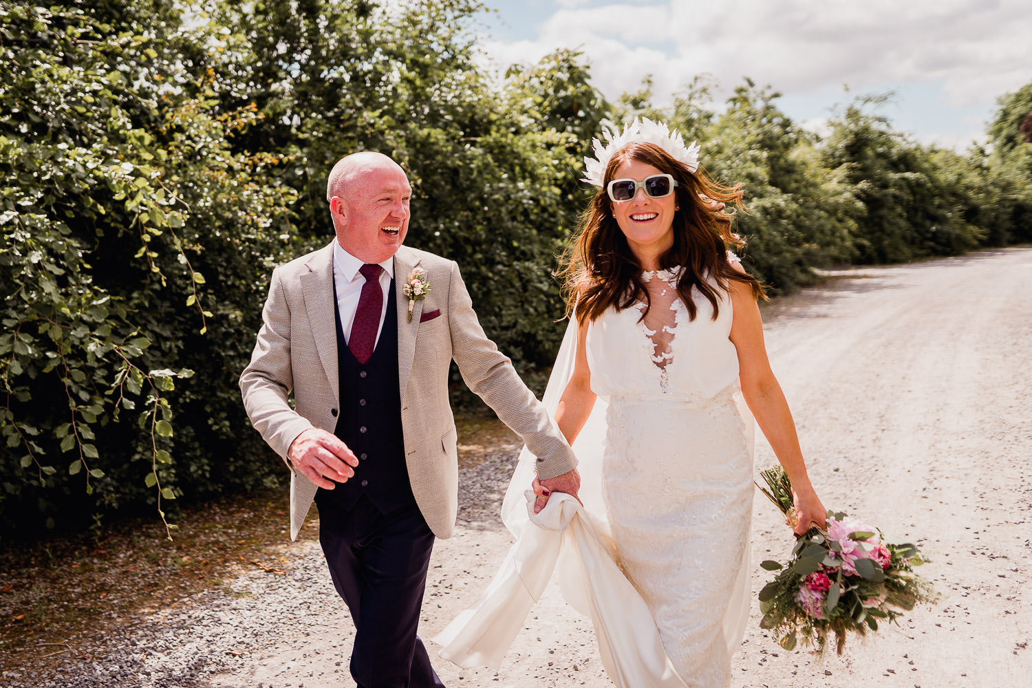 bride and groom standing in a forest smiling at each other