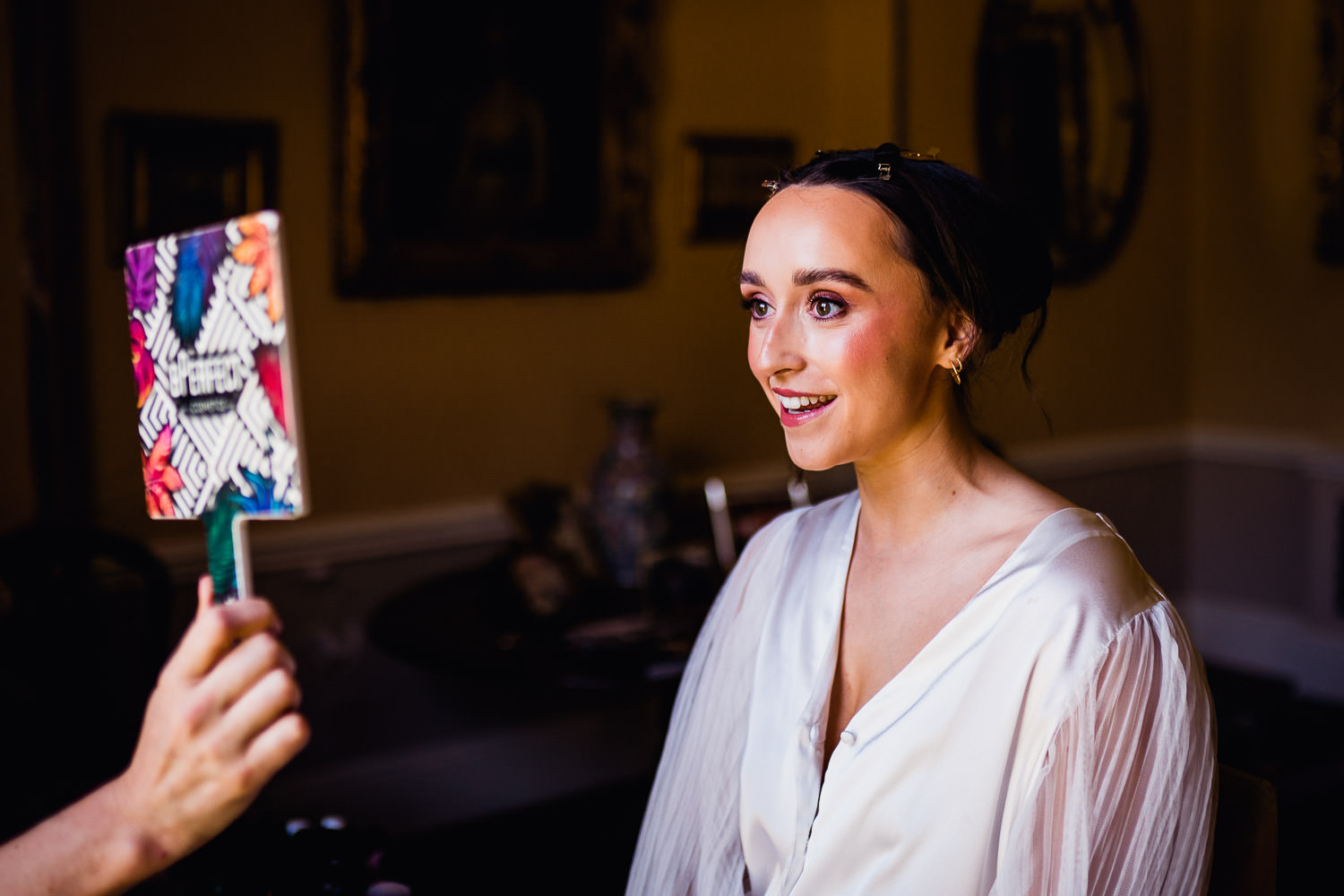 bride looking in a mirror smiling at Martinstown House